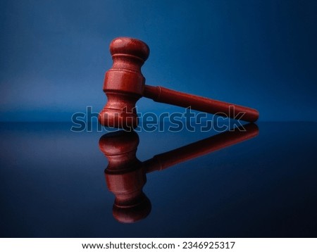 Wooden gavel with reflection on a black acrylic board. Justice and law concept