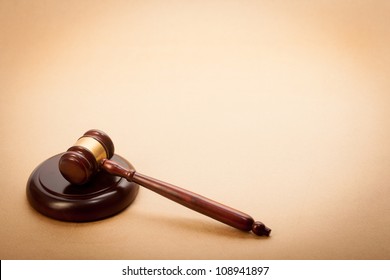 A Wooden Gavel And Soundboard On A Light Brown Background.