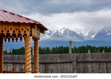 Wooden gazebo for relaxation against the backdrop of snowy peaks in the Kurai steppe in the Altai Republic. Beautiful landscape in a mountainous area on a cloudy summer day. Horizontal photo from trav