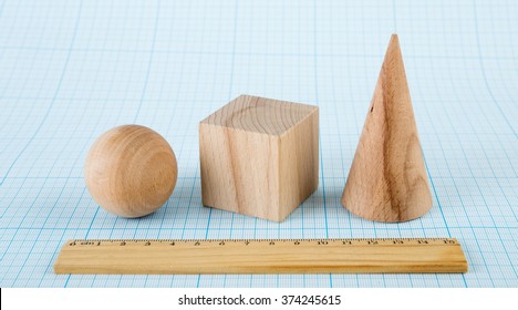 Wooden geometric shapes on graph paper