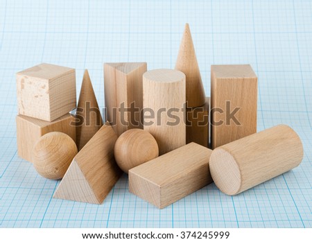 Wooden geometric shapes on graph paper