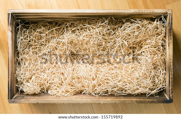 Wooden gift or display box filled with natural\
raffia or twine