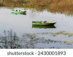 Wooden green colored fishing boat on the lake, reflection of the boat on the water. Authentic wooden boat. Sazlidere Lake, Istanbul, Turkey.