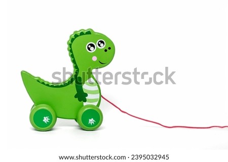 Wooden green dragon on wheels isolated on white background Educational children's toys