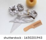 wooden Hairbrush, silk Scrunchy isolated on white. Flat lay Hairdressing tools and accessories as silver Hair Scrunchies, Elastic HairBands, Doughnut. hair scarf fixed on the scrunch