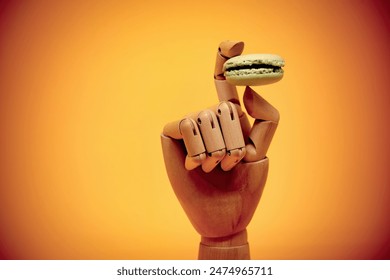 Wooden hand holding green macaroon - Powered by Shutterstock