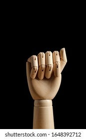Wooden hand of mannequin for drawing clenched into a fist on a black background. Show fist, threaten. Side view. Art model for drawing. Part of the body - hand, brush. 