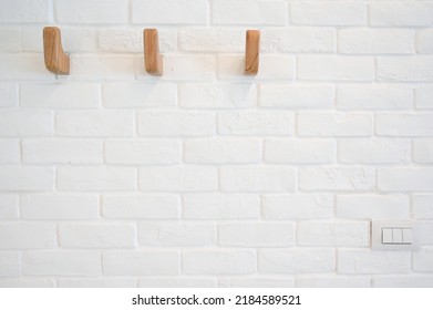 wooden hanger hook on white brick wall - Shutterstock ID 2184589521