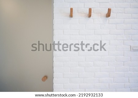 wooden hanger hook on white brick wall