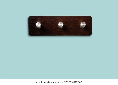 Wooden hanger for keys, clothes isolated on a blue, pastel background. The concept of storing keys, placing clothes in place. Towel holder.