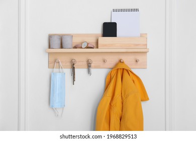 Wooden hanger for keys with different stuff on white wall