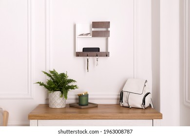 Wooden hanger for keys on white wall in hallway