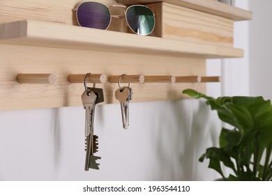 Wooden hanger for keys on white wall, closeup