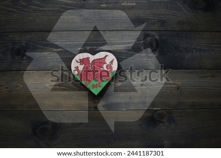 wooden heart with national flag of wales near reduce, reuse and recycle sing on the wooden background. ecological concept