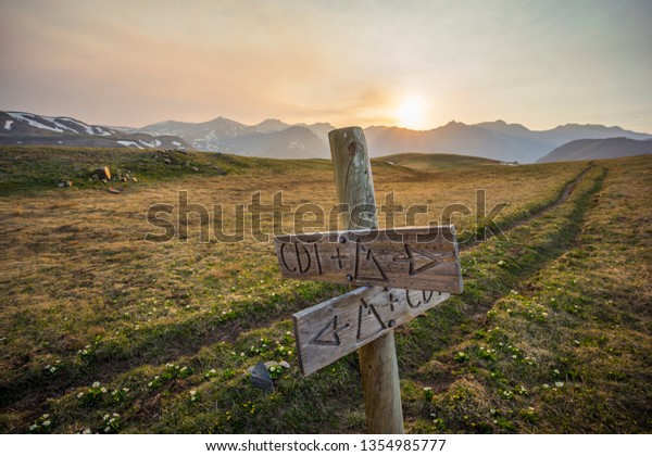 Wooden Hiking\
Trail Sign Marking Junction of Continental Divide Trail (CDT)\
& Colorado Trail (CT) In Colorado\'s San Juan Mountains -\
Sunset With Forest Fire Smoke in\
Background