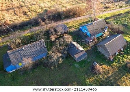 Wooden home in village. Country houses in the countryside. Aerial view of roofs of rural homes. Suburban house at countryside. Rural housing outside the city. Russian community in region, countryside.