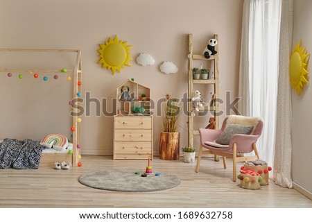 Wooden house bed detail cabinet and stair decor. Yellow sun and cloud decor. Pink chair in the room.