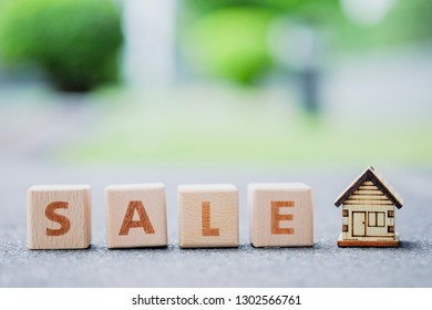 Wooden house and wooden blocks word SALE. Property sale and planning to investment propery