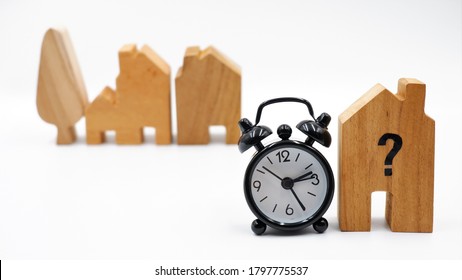 Wooden house with clock, business concept of housing market trends and property value. When is the best time to buy house or real estate investment after financial impact from coronavirus crisis.