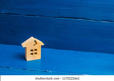 A Wooden House With A Crack. The Concept Of A Damaged House, Dilapidated Housing. Renovation, Repair And Restoration Of The Old Building. Property Insurance. Weather Element. Damage.