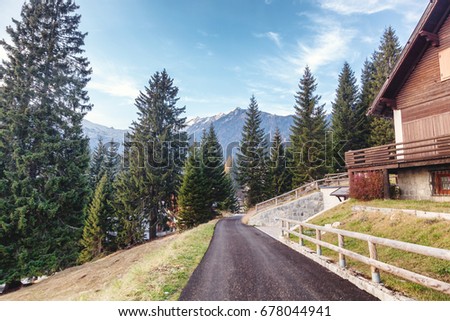A wooden house in the Dolmite Alps and a path. Beautiful mountain landscape