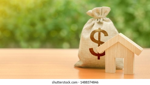 Wooden house figurine and a dollar money bag. Family budget, control and reduction of expenses. subsidized funds. Mortgage loan for purchase housing, construction or modernization. Tax, maintenance.