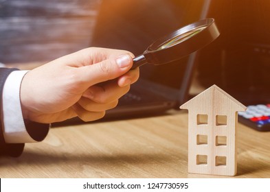 Wooden house and magnifying glass. Property valuation. Choice of location for the construction. House searching concept. Search for housing and apartments. Real estate concept. Home appraisal
