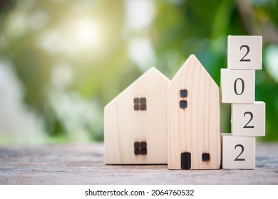 Wooden house model with wooden block number 2022 and copy space using as background concept to save money buying house, new year property, business, real estate and property concept.