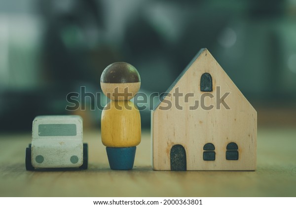 Wooden house model with car and figure of people.\
The concept of affordable housing and car, mortgages for buying a\
home or car.