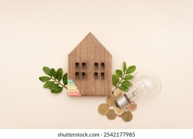 Wooden house model with green leaves, light bulb and coins on neutral background symbolizing energy efficiency and sustainability in homes - Powered by Shutterstock