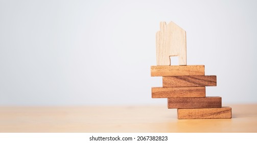 Wooden House Model Lay On Edge Of Wooden Stacking For Risk Asset Management And Insurance Of Real Estate Concept.