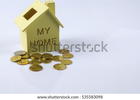 Wooden house model with pile of coin.  House finance concept.
