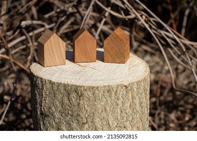 Wooden House Models On Tree Stump In The Outdoors. Concept Image For Wood As A Renewable And Sustainable Building Material For Modular Timber Architecture. 