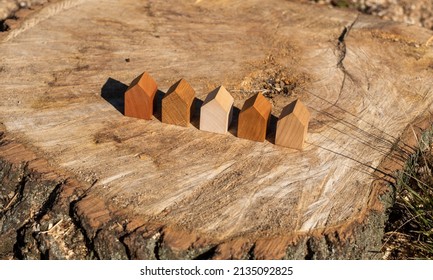 wooden house models on tree stump in the outdoors. concept image for wood as a renewable and sustainable building material for modular timber architecture.  - Shutterstock ID 2135092825