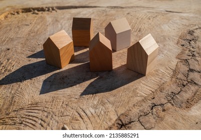 Wooden House Models On Tree Stump In The Outdoors. Concept Image For Wood As A Renewable And Sustainable Building Material For Modular Timber Architecture. 