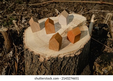 Wooden House Models On Tree Stump In The Outdoors. Concept Image For Wood As A Renewable And Sustainable Building Material For Modular Timber Architecture. 