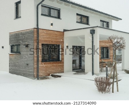 Wooden house modern house with windows in winter snowfall, Austria, showroom