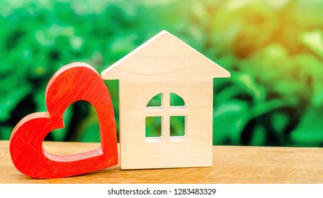 Wooden House And Red Heart. Concept Of Sweet Home. Property Insurance. Family Comfort. Affordable Housing For Young Families. Hotel For Lovers On Valentine's Day.