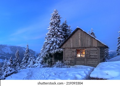 Wooden House In Winter Forest