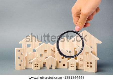 Wooden houses and magnifying glass. Property valuation. Home appraisal. Choice of location for the construction. House searching concept. Search for housing and apartments. Real estate