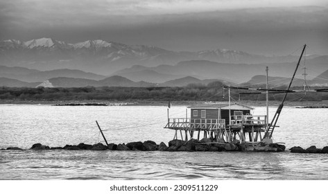 Wooden houses on the sea with fish nets at sunset. - Powered by Shutterstock