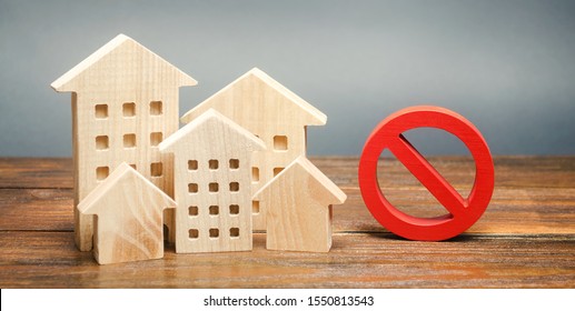 Wooden houses and a prohibition sign. Inaccessible and expensive housing. Restrictions and a ban on the construction of buildings. Interdictions within settlements. Inaccessibility Index - Shutterstock ID 1550813543