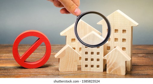 Wooden houses and a prohibition sign. Inaccessible and expensive housing. Restrictions and a ban on the construction of buildings. Interdictions within settlements. Inaccessibility Index - Shutterstock ID 1585823524