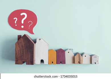 Wooden houses with question marks, housing crisis, confused decision, insecure investment, choosing right property concept