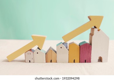 Wooden Houses With Yellow Arrows Up. Housing Boom, Property Market Growing, High Demand For Real Estate, House Prices Rising Concept