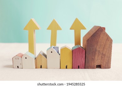 Wooden Houses With Yellow Arrows Up. Housing Boom, Property Market Growing, High Demand For Real Estate, House Prices Rising Concept