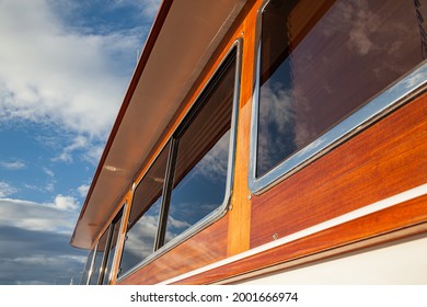 Wooden Hull Of A Yacht With Rectangular Portholes Against The Sky, Side View.