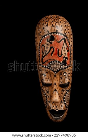 Wooden Indonesian decorative mask against a black background