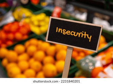 Wooden information label sign with text INSECURITY against defocused store shelves message. Global hunger, inflation, high prices, increasing living expenses and poverty, financial crisis, food supply