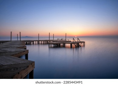 Wooden jetty on the beach of Carmolí in the Mar Menor, in a warm sunrise, in Cartagena, Region of Murcia, Spain - Shutterstock ID 2285443491